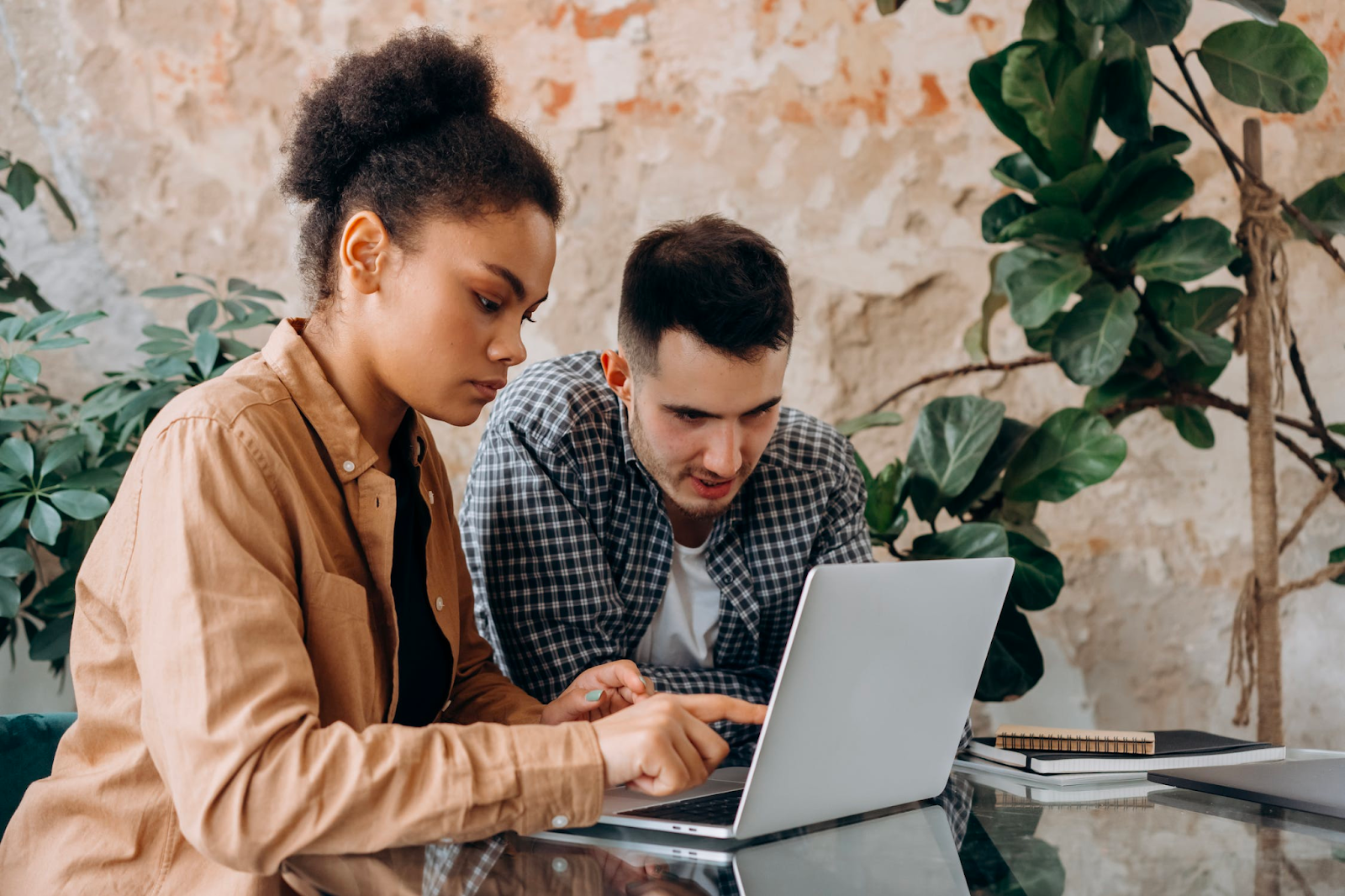 Two employees looking at KPI’s on a laptop