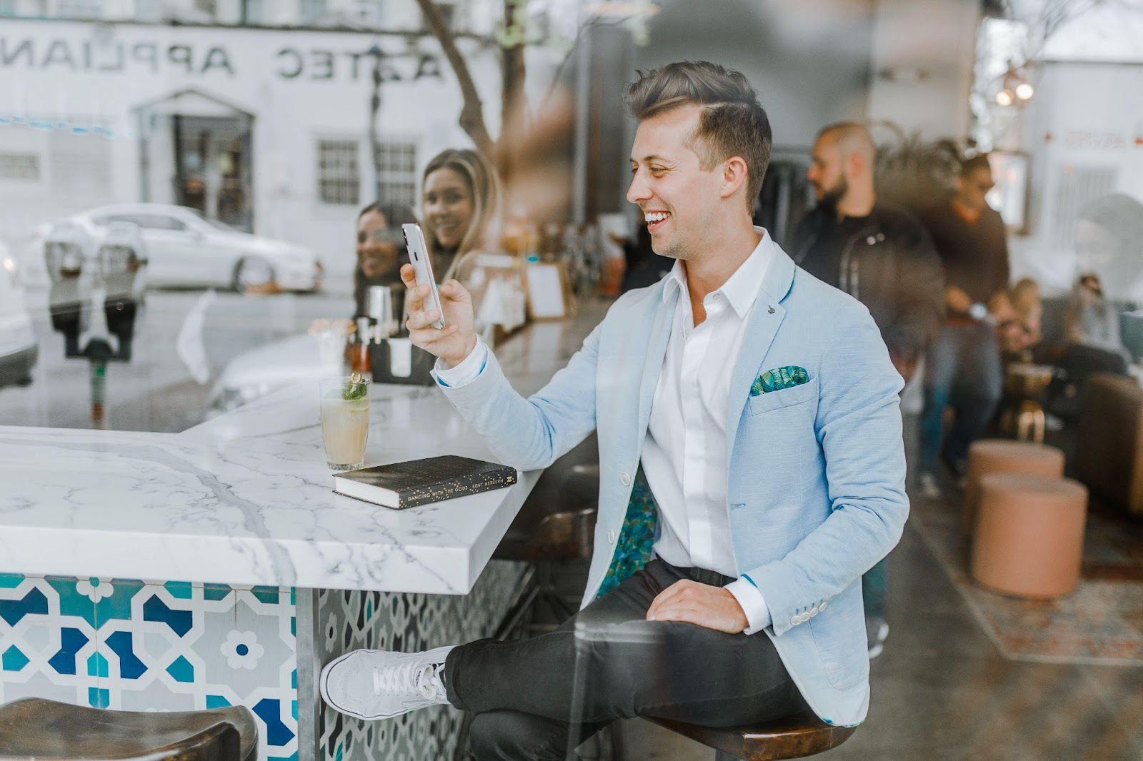 a man in a suit smiling at his phone