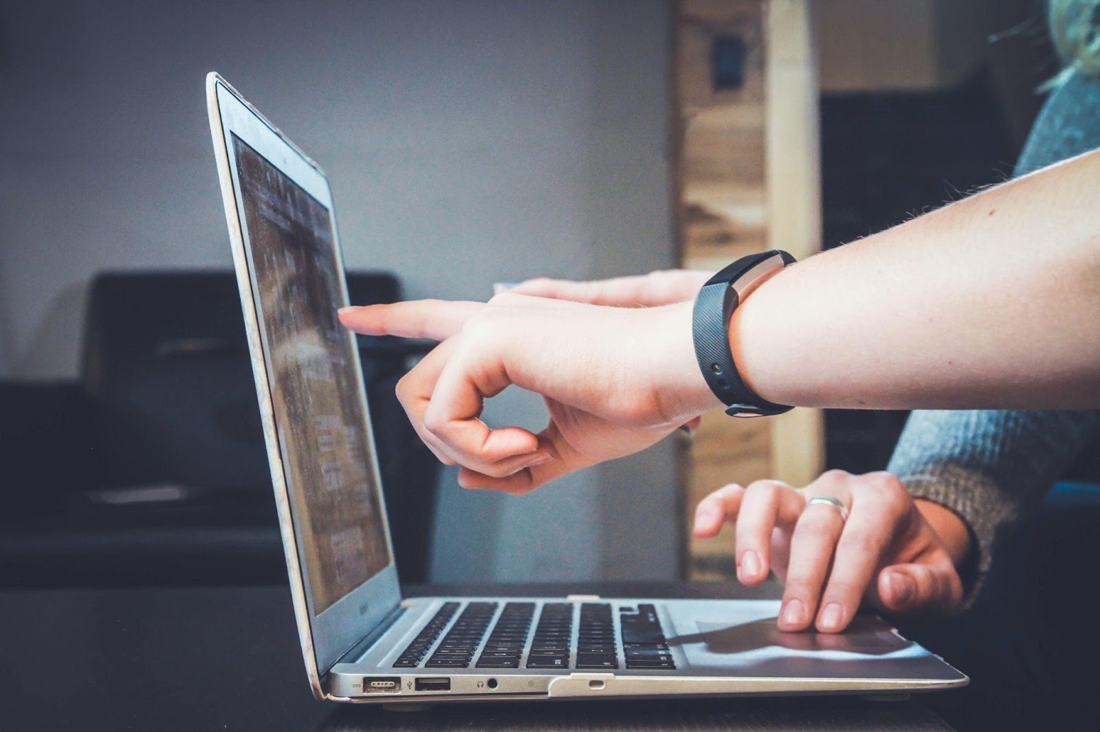 people working and pointing at a laptop