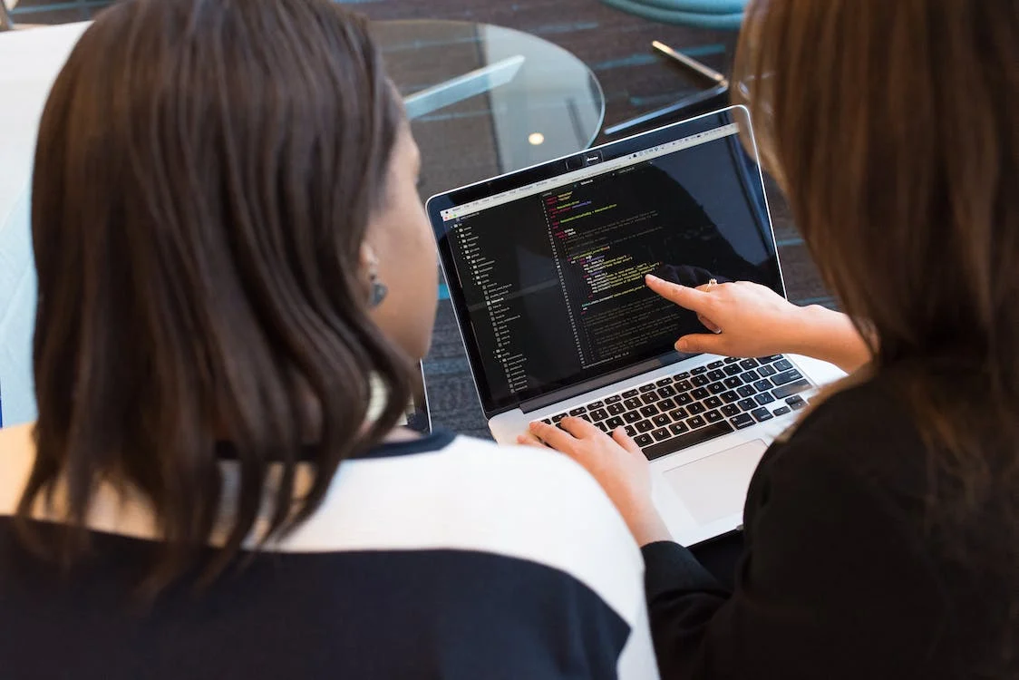 2 people working on data on their laptop